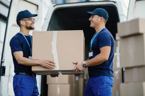 happy-manual-worker-cooperating-while-carrying-cardboard-boxes-delivery-van (1)-min